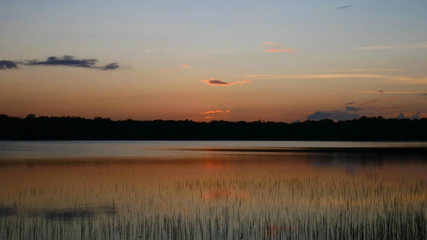 the sun is setting over a large body of water