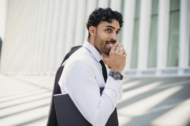 a man in a vest, white shirt and black tie is standing outside of a building