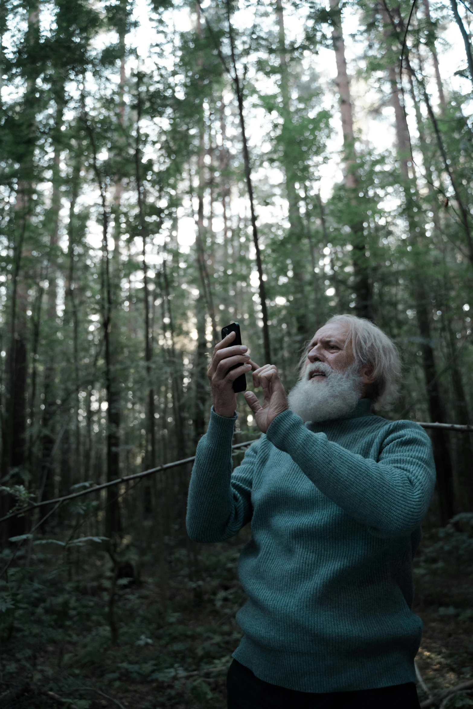 an elderly man is taking a po in the forest