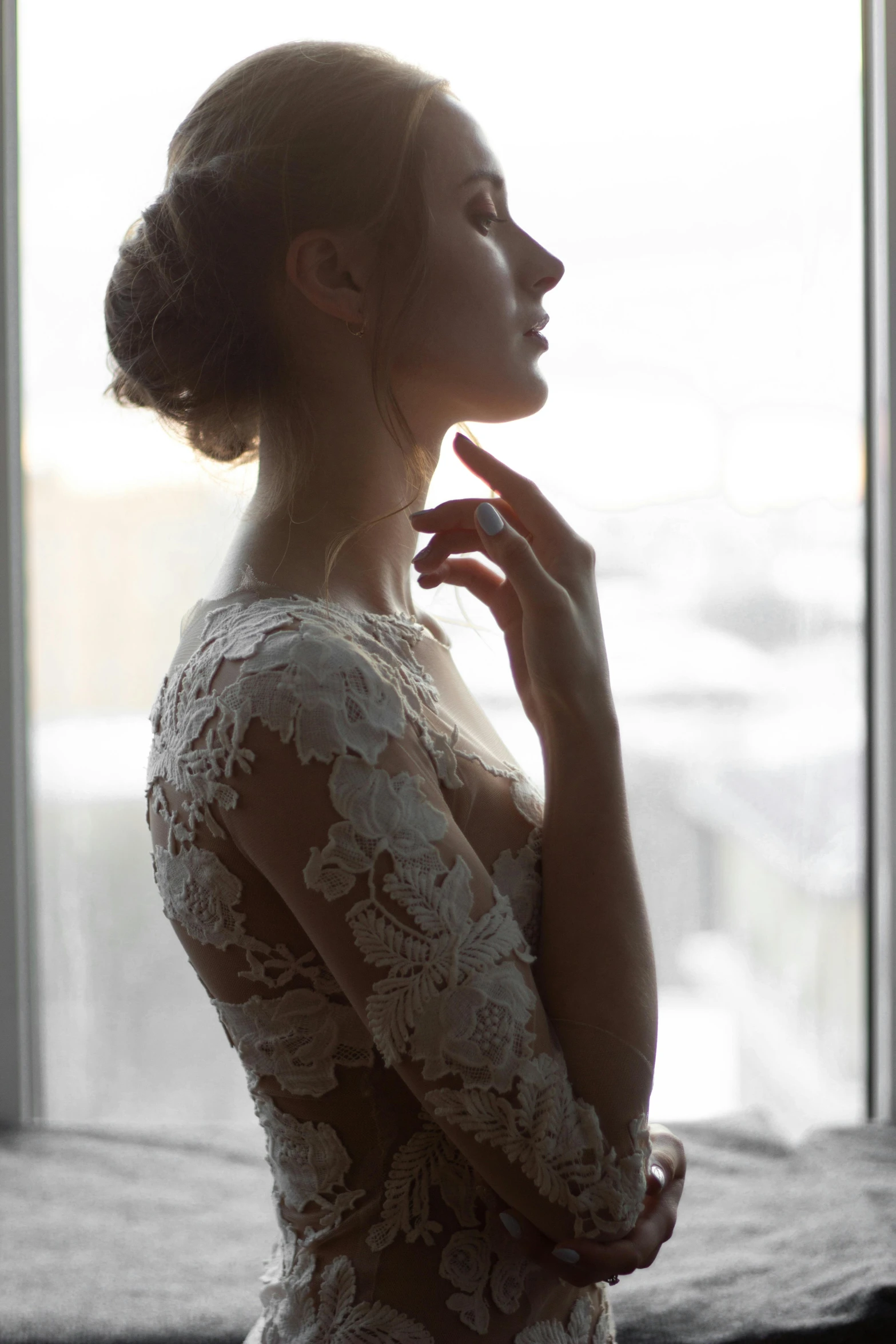 a woman in an elegant lace dress is holding her hands to the side and touching her lips