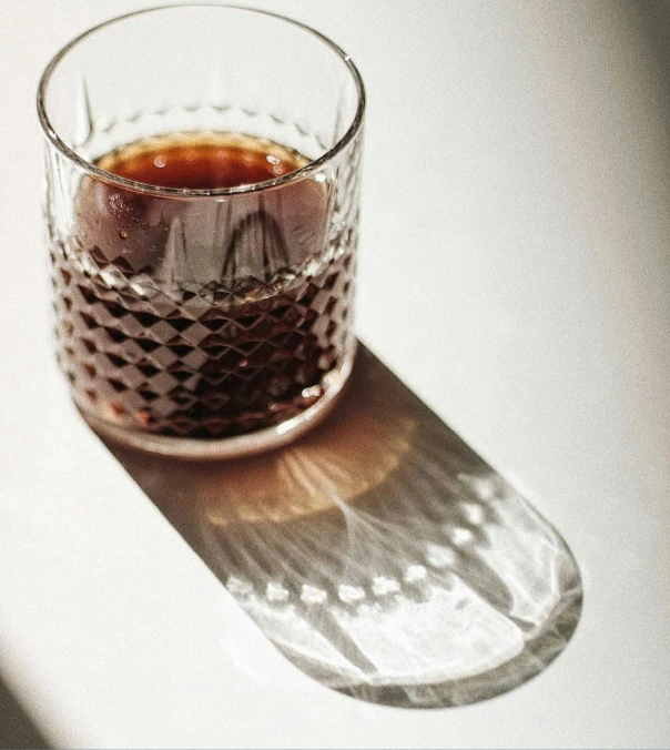 a glass with liquid in it sitting on a surface