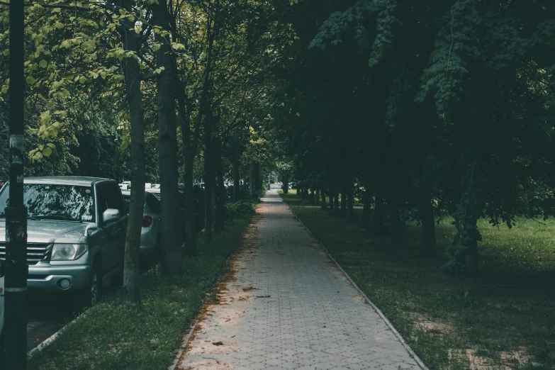 a vehicle is parked on the side of a paved walkway