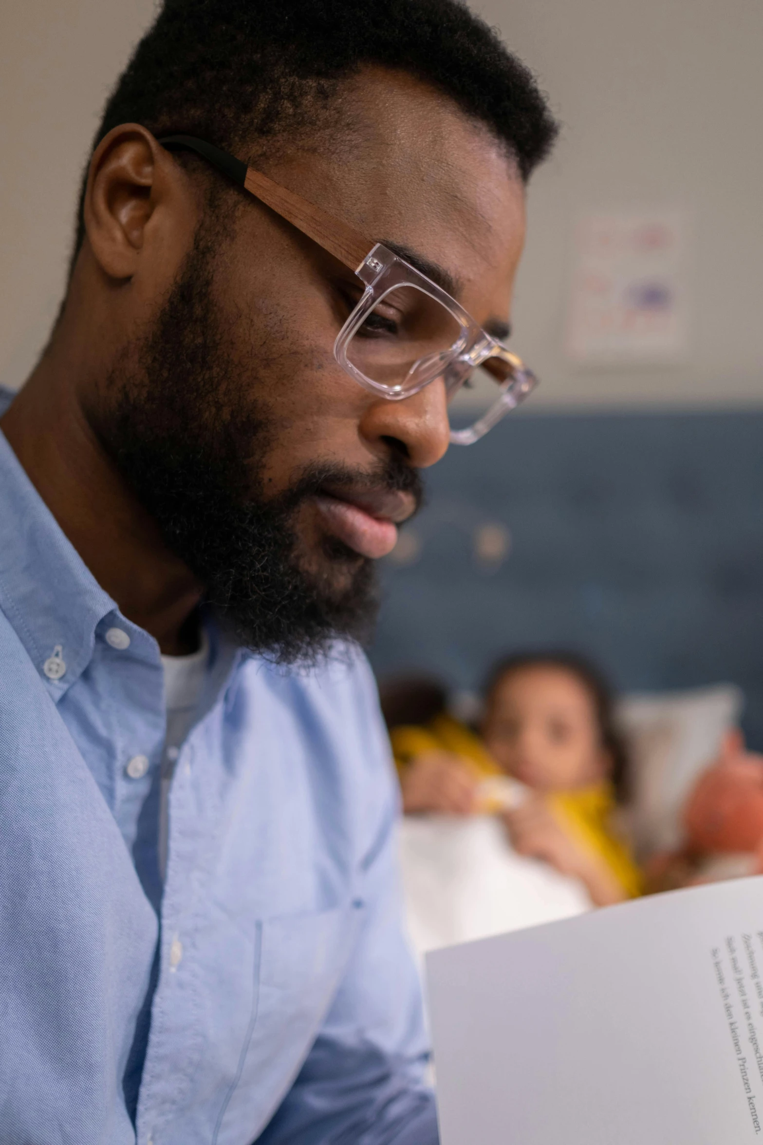 a man reading a book while wearing glasses