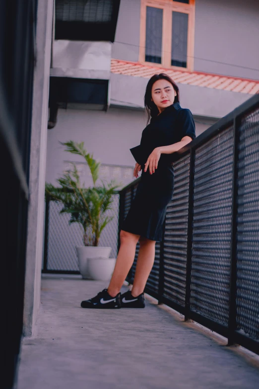 a girl leaning on a fence near a building