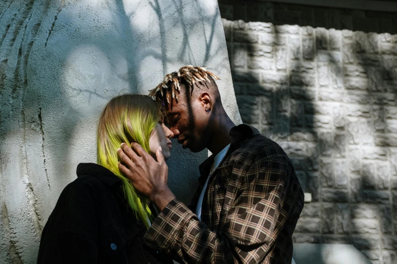 a man and woman leaning against a wall