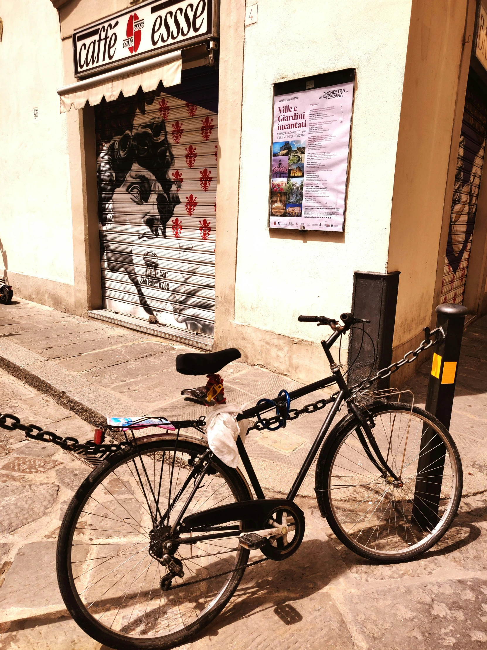 a bike  to a post and sitting on a street