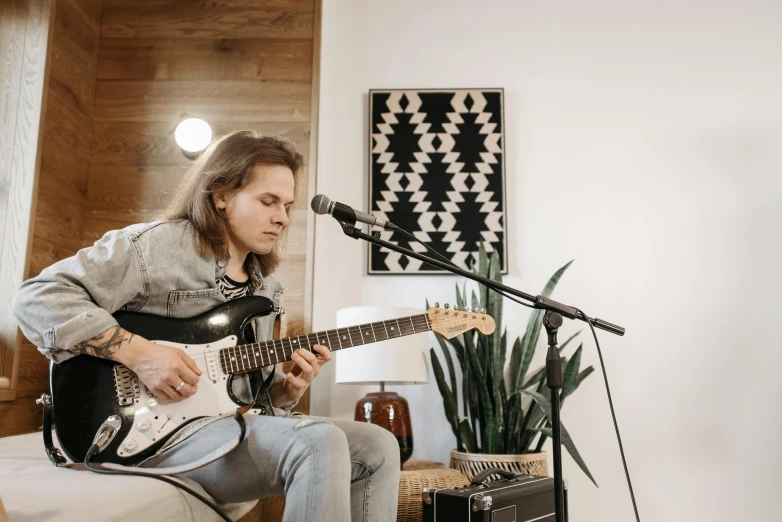 a person with long hair playing guitar in a house