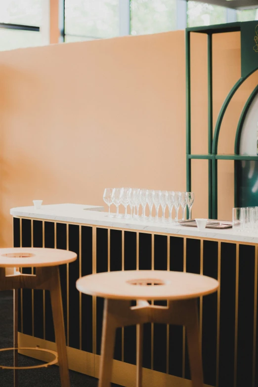 several wine glasses are placed on the bar, near a clock