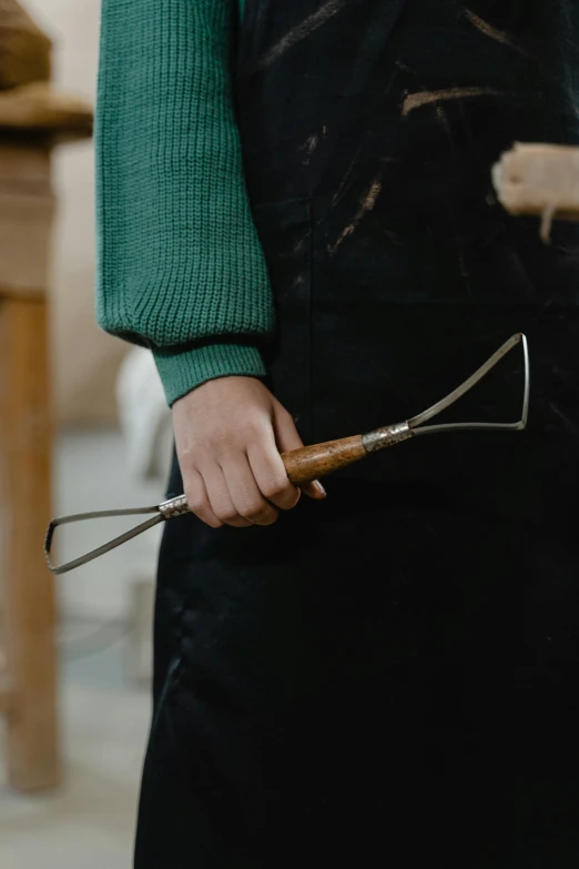 a person is holding a small metal piece of wood