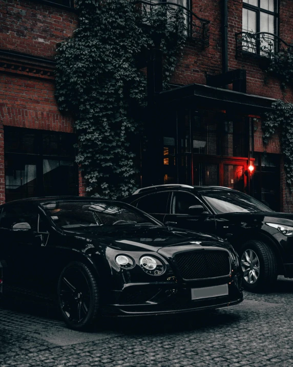 a man standing near two cars in front of a building