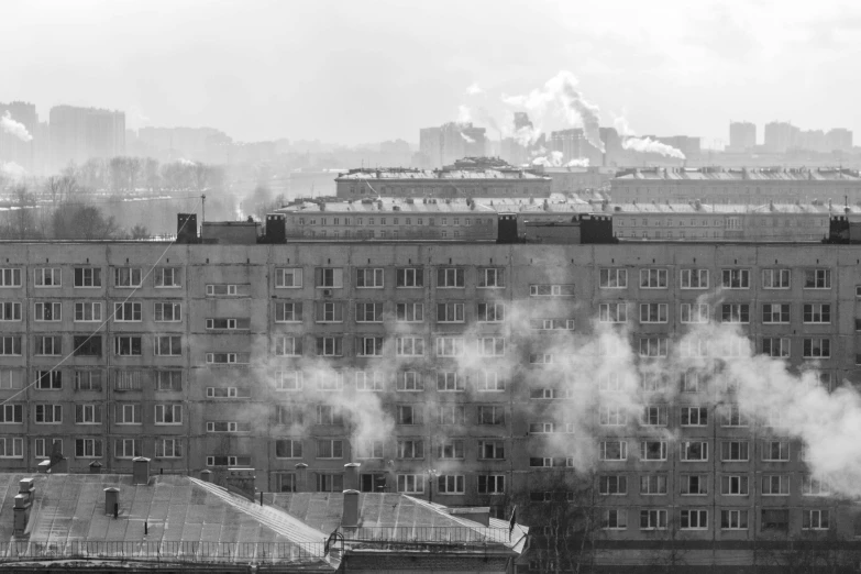 some steam rises from the smoke stacks of buildings