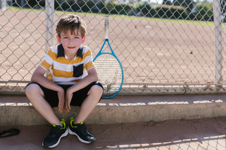  sitting next to tennis racket waiting for play