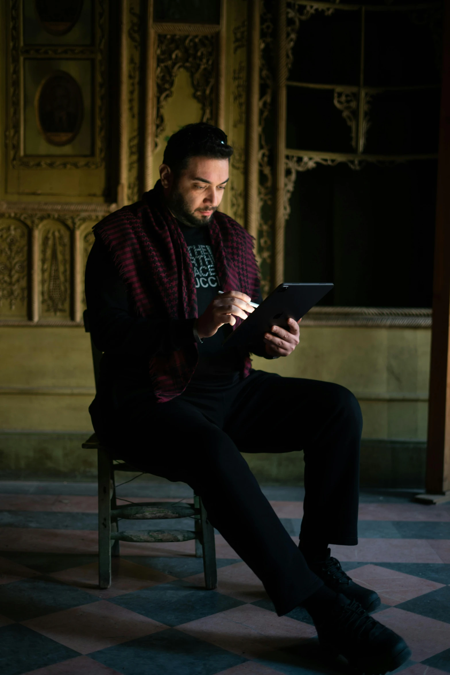 a man sitting in a chair holding a tablet