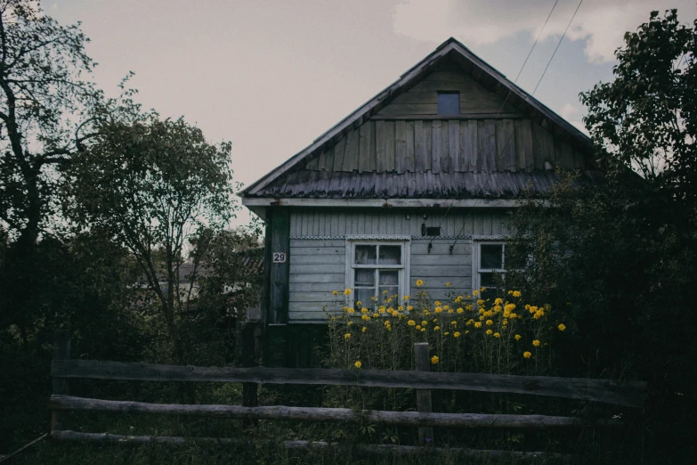 a house that is near a fence and some trees