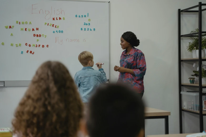 a woman teaching a class of children in a classroom