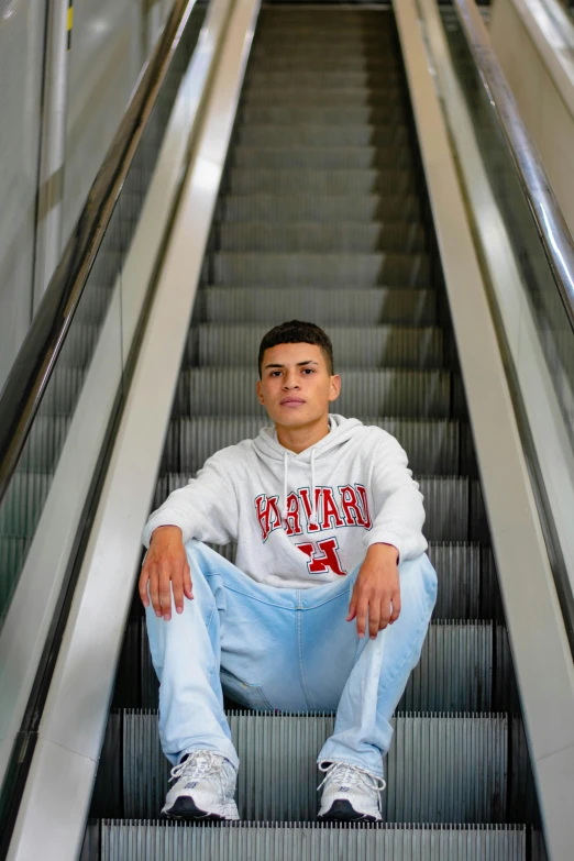 a man in sweat pants is sitting on the stairs