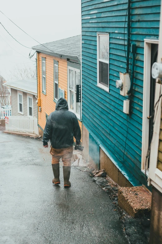 the man walks on a street that is flooded with water