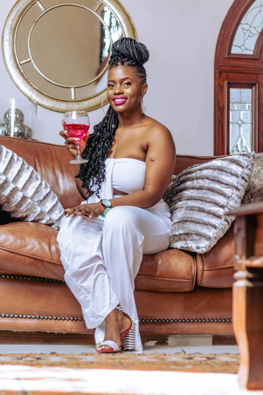 a woman sitting on a couch with a glass of wine in her hand