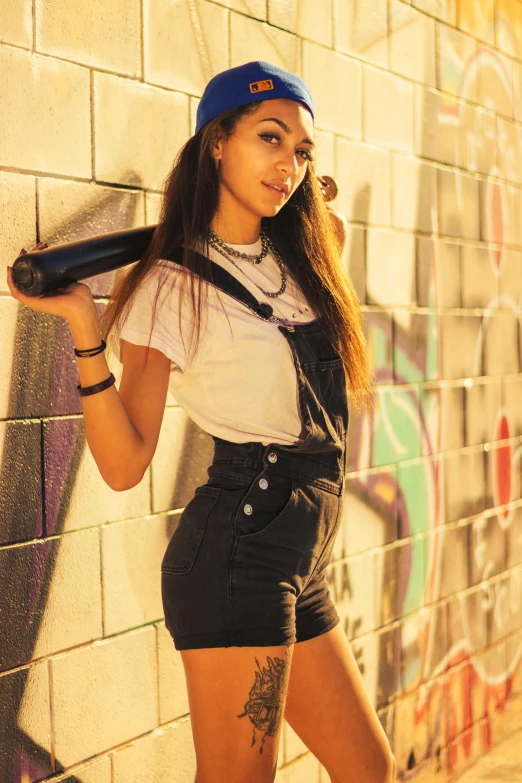 a woman holding a blow dryer while standing against a wall