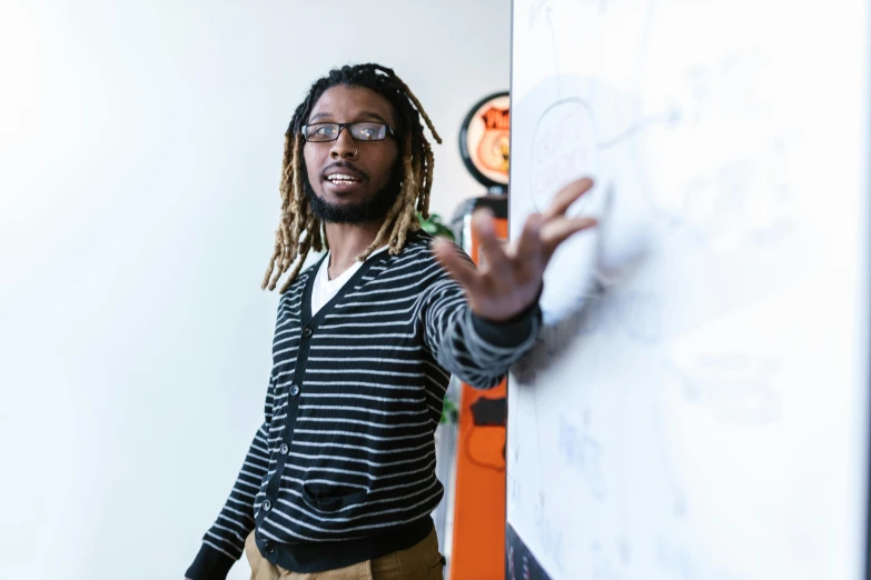 a man standing next to a whiteboard in a room