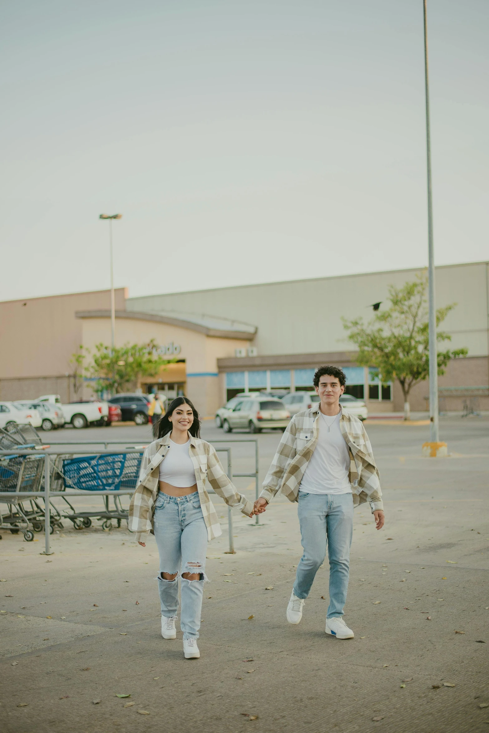 two people walking through an empty parking lot