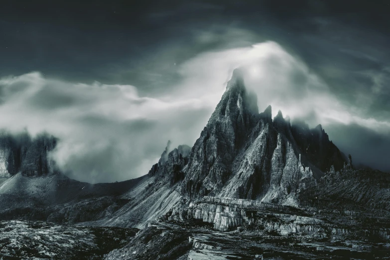 a black and white po of a mountain with storm clouds