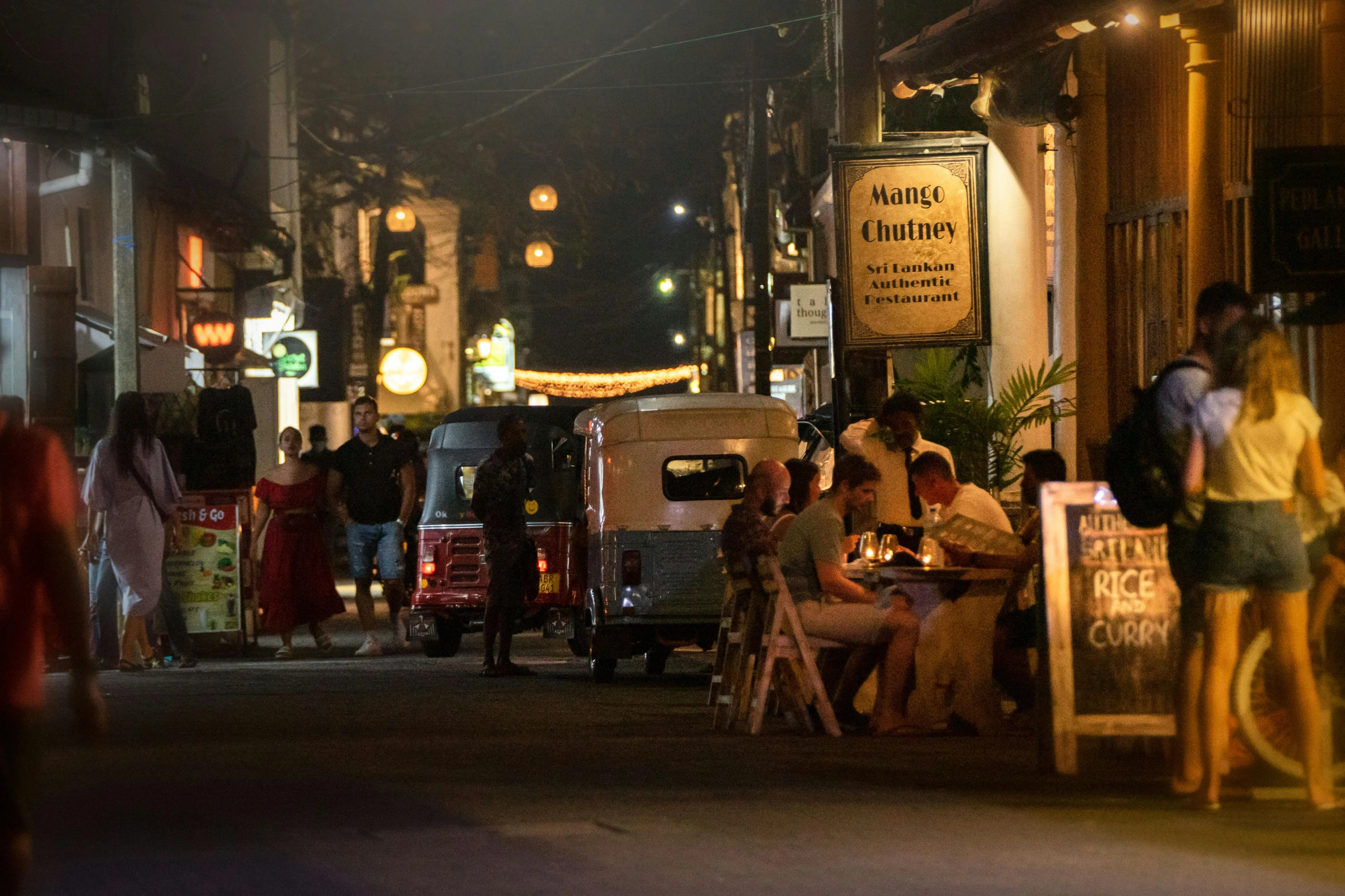 people are sitting outside a building at night