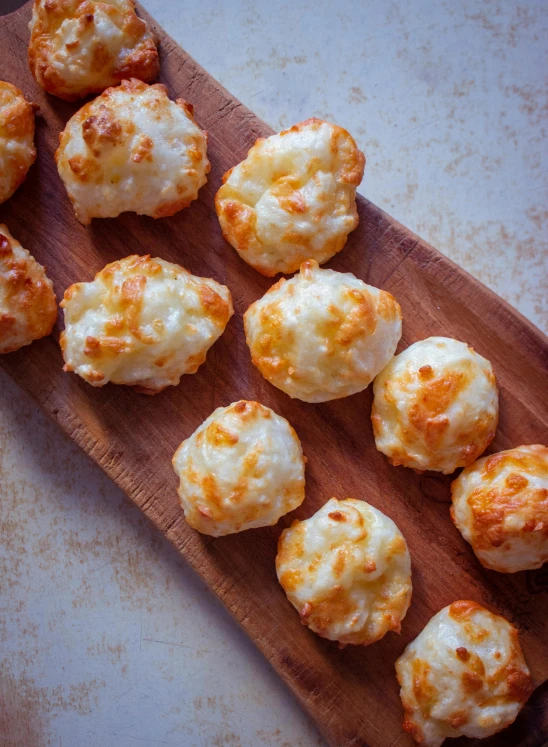 some little bites with cheese on a  board