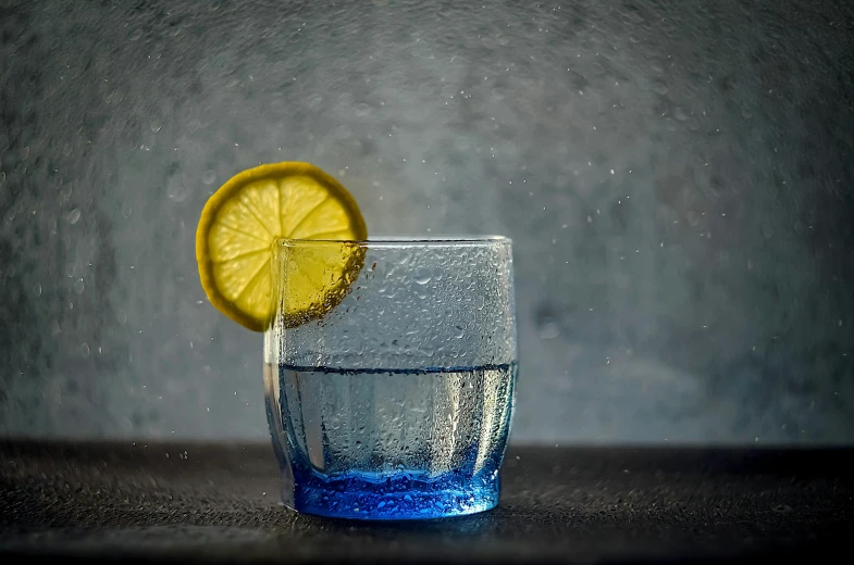 a small glass with water and a lemon slice