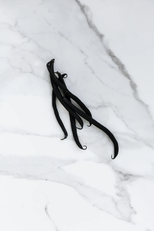 long black hair clips lying on a marbled surface