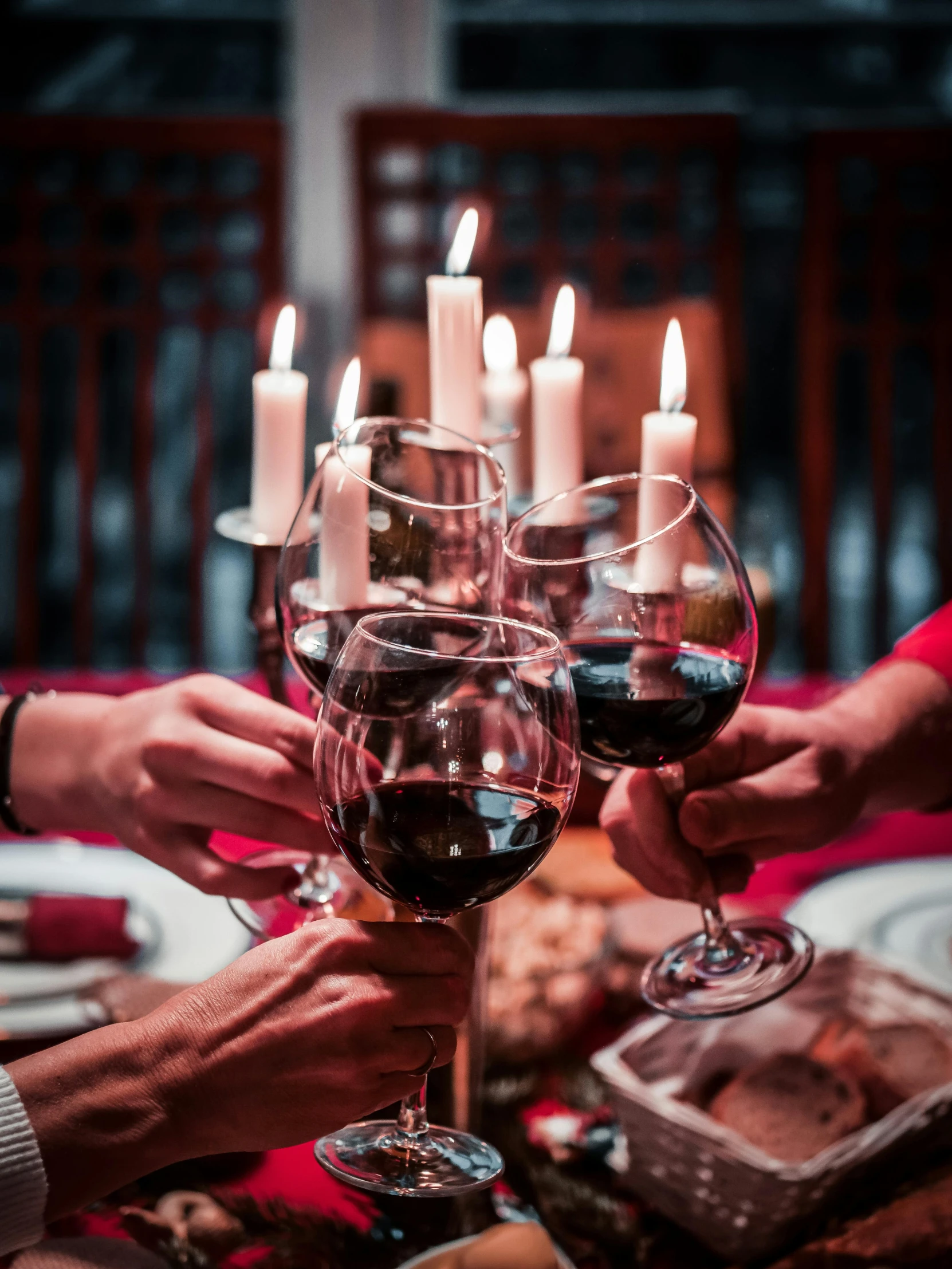 people toasting wine glasses over a dinner table