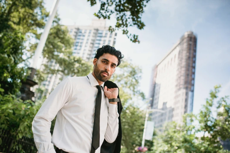 the man is posing in the city wearing a shirt and tie