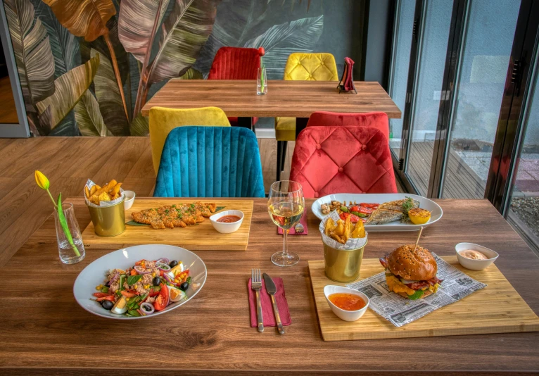 a table set with two bowls of food, cups of wine and plates of food