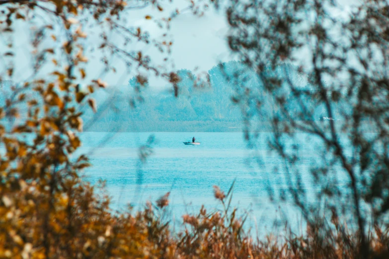 a lone boat is in the water in a blurry po