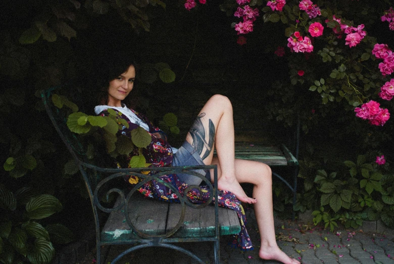 a woman laying on a chair outside in a garden
