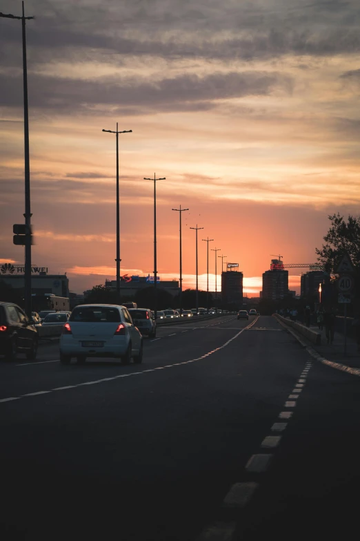 traffic sits on the side of a highway at sunset