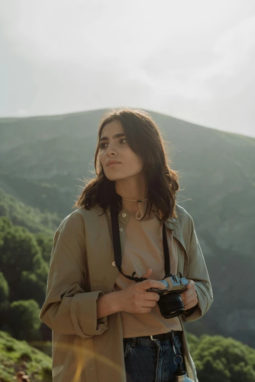 a woman holding her camera is seen looking up