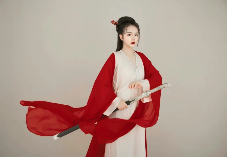a woman in red and white holding an oriental style sword