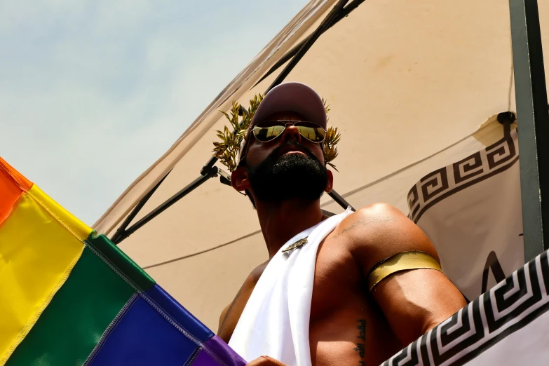 a man is holding a rainbow flag and beard