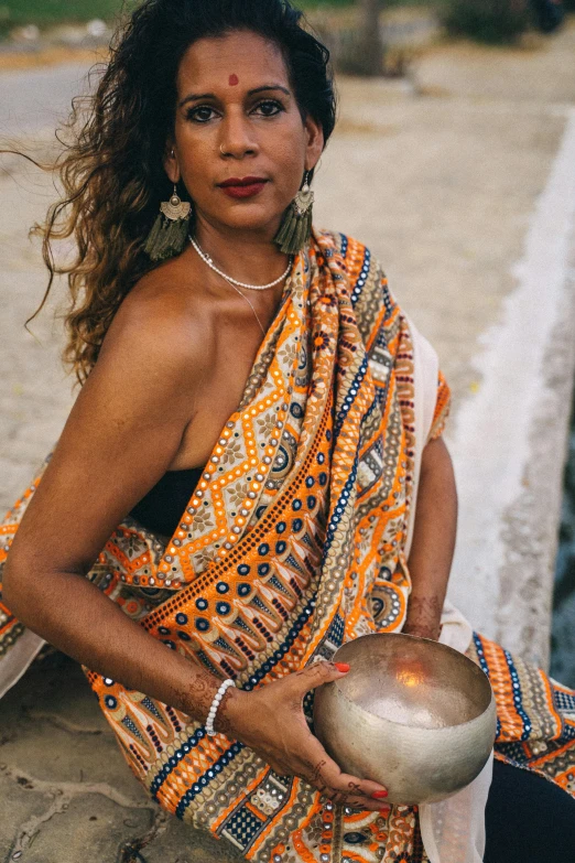 an indian woman with beads holding a bowl