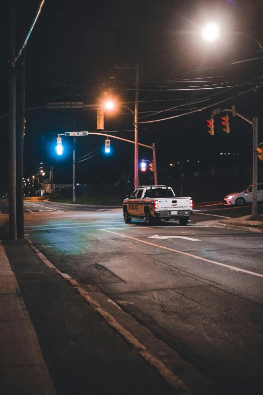 a police car driving through the dark on a street