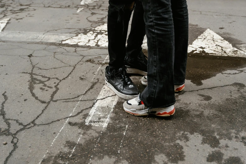 two people standing on top of each other's shoes