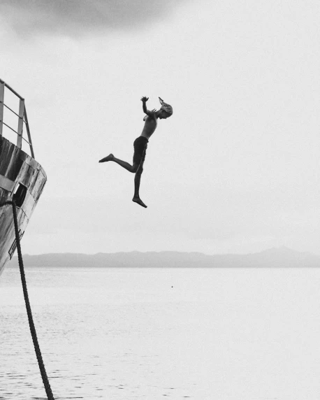 a man jumping off the top deck of a boat