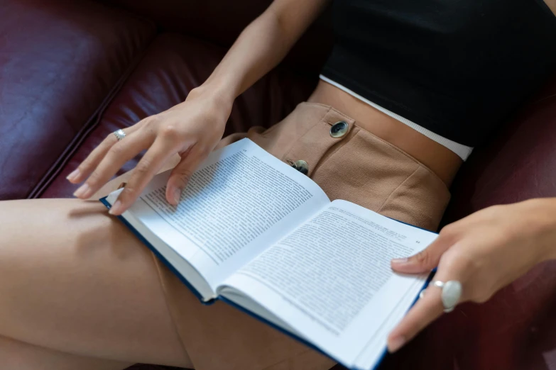 a person sitting on a couch holding an open book