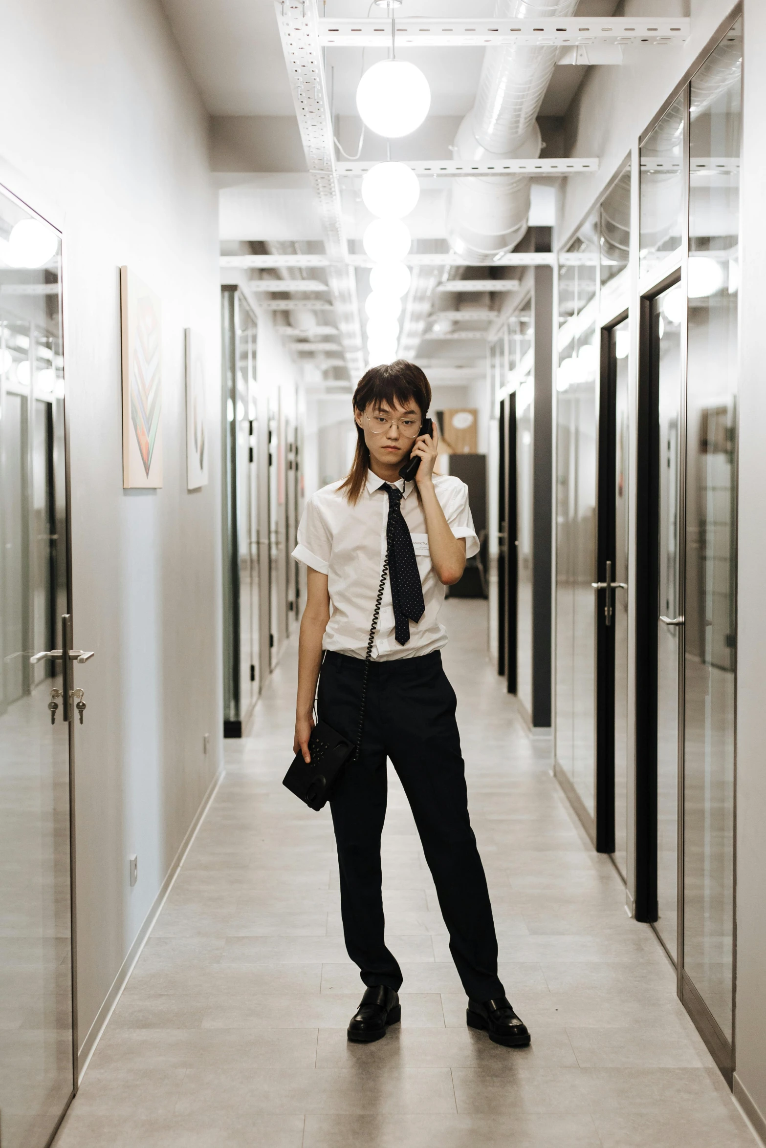 a woman with a tie and shirt on is talking on the phone