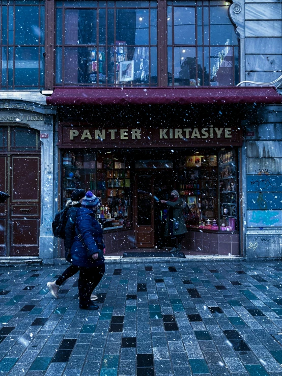 a person in blue jacket and black coat walking on tile