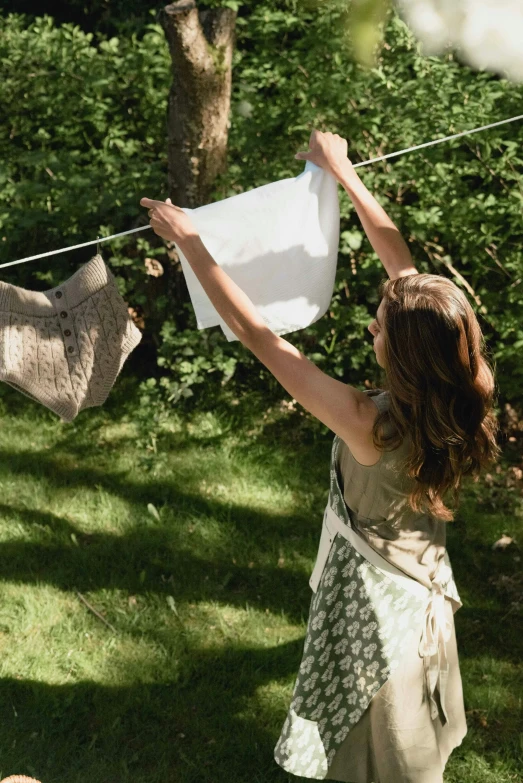 a woman holding two towels and a white bag