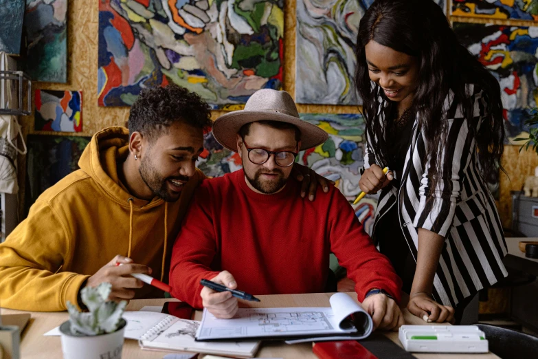 three people who are writing in a notebook