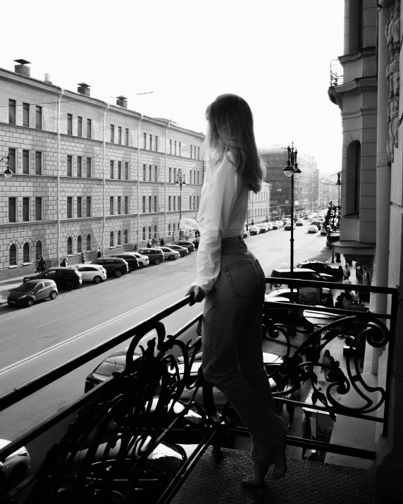 a woman stands on the balcony overlooking bikes