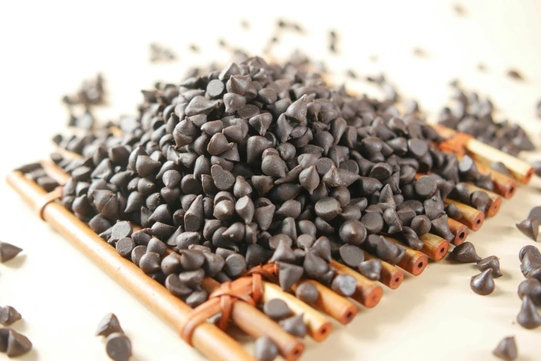 a pile of small black beans on a white background